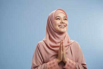 Beautiful Asian Muslim woman with a radiant smile, making an Eid Mubarak greeting gesture, isolated on a clean background, representing the concept of religious lifestyle