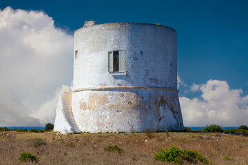 A cylindrical white tower with a flat roof and a small window. Located in Punta Pizzo, Salento, Italy, built in 1569 to defend against invaders. - 746687407