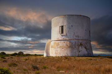 White WatchTower with a flat roof and a small window. Located in Punta Pizzo, Salento, Italy, built in 1569. - 746687423