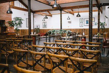 Fototapeta na wymiar Rustic industrial wedding venue with wooden chairs