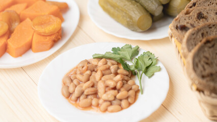Mixture of nuts, buckwheat porridge in clay plate, glass of water, beans, pickled cucumbers, boiled potatoes, boiled pumpkin, food Great Orthodox Lent.