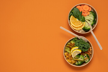 Takeaway food salads Buddha bowl in round cardboard containers. Broccoli and quinoa, kale and chickpeas bowls. Top view on bright background