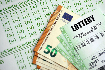 Green lottery tickets and euro money bills on blank with numbers for playing lottery close up