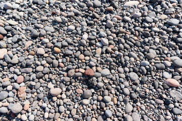 Detail of cobblestones of the famous Black Beach, Santorini. Background, natural stone, texture.