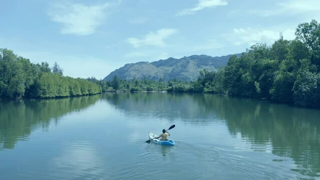 A man paddling alone on a river