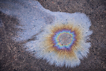 Oil spill on asphalt in the form of a stain. Abstract background from motor oil, gas or petrol...