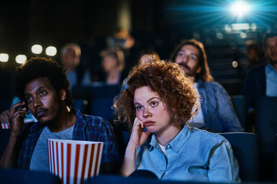 Bored young couple sitting in the movie theater