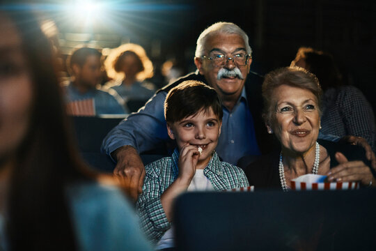 Grandparents with grandson in the movie theater watching a film