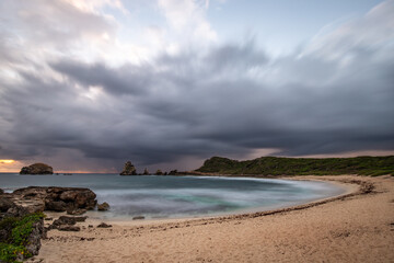 Fototapeta na wymiar Stony coast with sharp rock formations on a bay in the sea. rainy sunrise, dramatic mood. Pointe des Chateau overlooking Pointes des colibris on Grande Terre, Guadeloupe, French Antilles, Caribbean