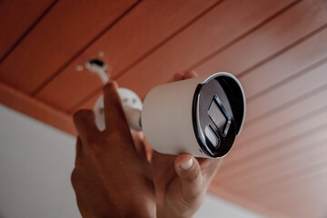 A technician installs a CCTV camera in a modern apartment.
