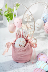 Spring Easter still life. Painted eggs in a silk decorative bag with bunny ears. Easter decor on...
