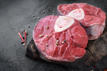 ossobuco. Raw beef ossobuco steak, Italian ossobuco with cooking spices. Black background. Top view