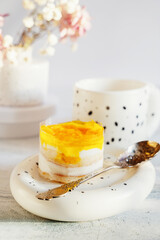 dessert made from yogurt and jelly. Layered orange peach and biscuit dessert in transparent film, layered yogurt dessert idea. Soft selective focus