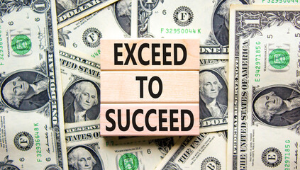 Exceed to succeed symbol. Concept words Exceed to succeed on beautiful wooden blocks. Dollar bills....