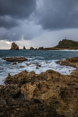 Stony coast with sharp rock formations on a bay in the sea. rainy sunrise, dramatic mood. Pointe des Chateau overlooking Pointes des colibris on Grande Terre, Guadeloupe, French Antilles, Caribbean