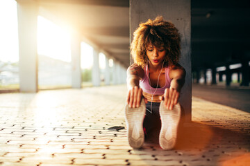 Young woman stretching before exercising and jogging in a parking lot