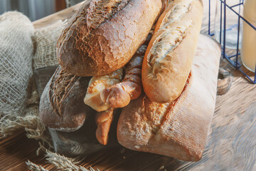 Assortment of various delicious freshly baked breads on a white wooden background. Ciabatta, grissini, pastries, baguette of various varieties. Homemade healthy bread, close-up