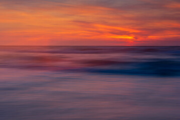 blurred sea, illuminated with the colors of the setting sun - obrazy, fototapety, plakaty