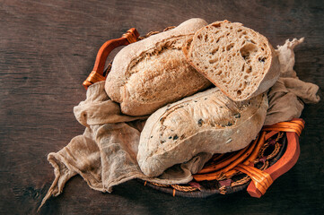Delicious freshly baked sourdough bread without yeast on a wooden background. Homemade healthy bread in a basket, close-up