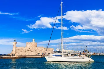 Poster Greece travel, Dodecanese. Rhodes island.  Mandraki Harbor with symbol statue of deer , saillboats and old lighhouse © Freesurf