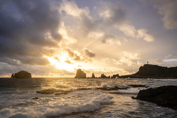 Stony coast with sharp rock formations on a bay in the sea. rainy sunrise, dramatic mood. Pointe...