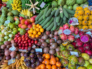 Exotic tropical fruit stall at Mercado dos Lavradores, Funchal, Madeira island, Portugal, Europe. Display of local healthy specialities on farmer market. Travel destination for food lovers. Tourism