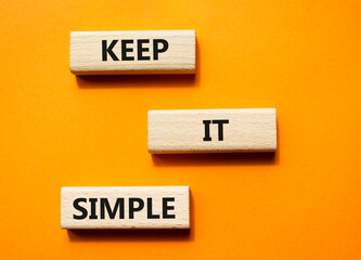 Keep it Simple symbol. Concept words Keep it Simple on wooden blocks. Beautiful orange background....