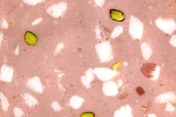 close up of sliced mortadella bologna with pistachios, top view of the texutre of a traditional italian pork sausage