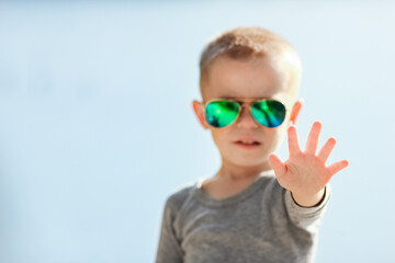 A Happy child in glasses from the sun on nature in the park travel
