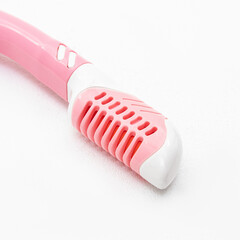 Pink snorkel for snorkeling and diving on white background. The breakwater closeup