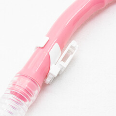 Pink snorkel for snorkeling and diving on white background. Plastic attachment to the mask closeup