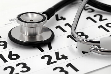 black stethoscope on calendar page, concept for scheduling a doctor's appointment or annual checkup
