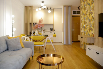 Modern cozy apartment with a touch of yellow, living room with sofa and dining table,	