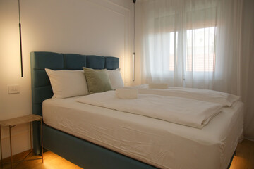 Simple, modern bedroom - King size bed with hidden LED lighting underneath and elegant bedside table	