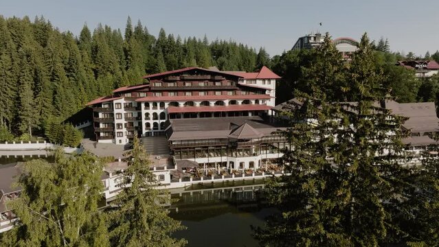 On a sunny day in the middle of a forest capturing with a drone a beautiful landscape of a vacation cabina