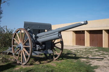 Detail of an old military field cannon with wooden spoke carriage wheels at Longues-sur-Mer battery (Batterie de Longues-sur-Mer)