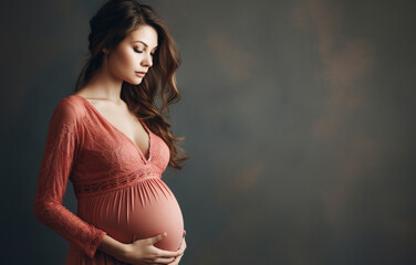 Portrait of the young pregnant woman in red transparent peignoir. Image of pregnant woman touching her belly with hands. Pregnant middle aged mother portrait, caressing her belly. - 746757887