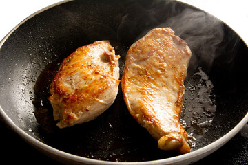 Fried chicken inside a black skillet pan in top aerial view