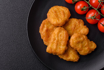 Delicious fresh crispy chicken nuggets on a dark concrete background