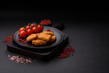 Delicious fresh crispy chicken nuggets on a dark concrete background