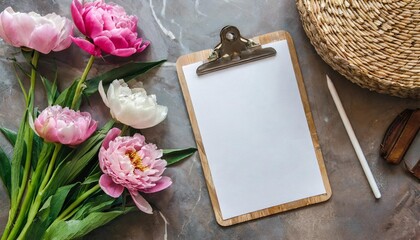 blank paper sheet clipboard tablet pad with mock up copy space beautiful home office table desk workspace with fresh pink peony tulip flowers marble tray rattan casket albums flat lay top view