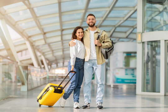 Ready For Trip. Happy Young Couple Posing In Airport Terminal,