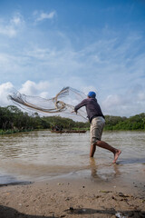 Shrimp fisherman pulling his net in a river