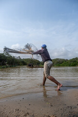 Shrimp fisherman pulling his net in a river