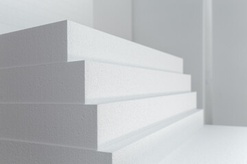 Close up of large panels of Styrofoam are stacked in a warehouse.