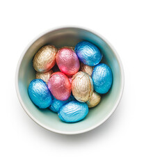Easter chocolate eggs wrapped in aluminium foil in bowl isolated on white background.