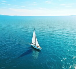 a sail boat floating in open ocean aerial