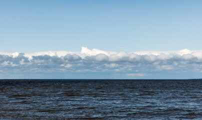 Baltic Sea water is under blue sky with white clouds on a sunny day