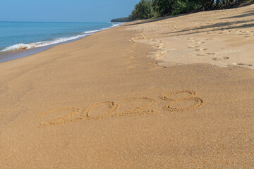Fototapeta na wymiar 2028 written in the sand on the beach - Happy New Year 