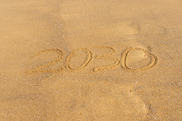 Fototapeta na wymiar 2030 written in the sand on the beach - Happy New Year